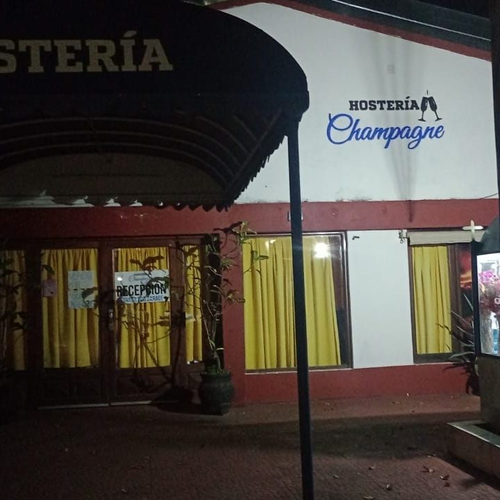 Cartel de la Hostería Champagne iluminado de noche